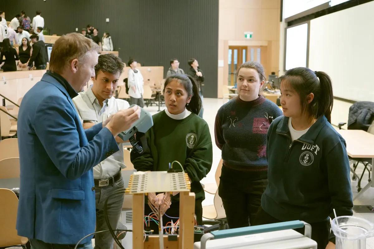 Professor Roman Genov (left) talks to (from left to right) Mohammed Abdolrazzaghi (ECE PhD candidate) and the Capstone team of Kimberley Orna, Aurora Nowicki and Selena Liu (all Year 4 ElecE). The team developed a wireless method of transferring power to multiple brain implants. They presented their project in April at the ECE Capstone Design Fair. (photo by Matthew Tierney)